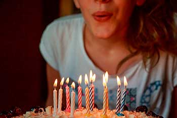 Chica soplando las velas de la tarta de cumpleaños
