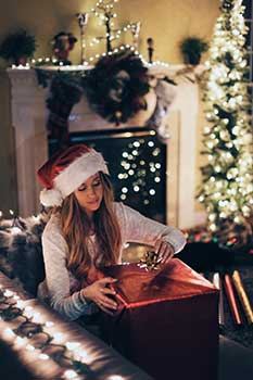 Chica abriendo los regalos de Navidad